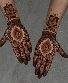 two hands with henna designs on them