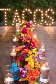 a long table with candles and flowers on it is set up in front of the word love