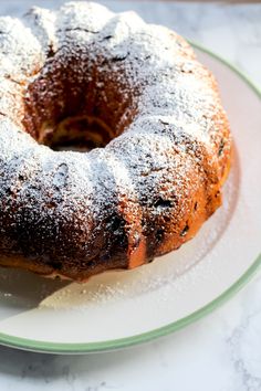 a bundt cake sitting on top of a white plate covered in powdered sugar