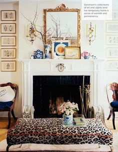 a living room filled with furniture and a fire place covered in pictures on the wall