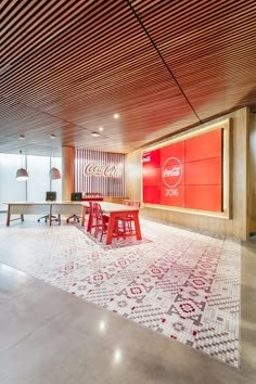 an office with red and white decor in the center, along with a large rug on the floor