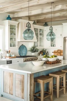 a large kitchen with white cabinets and wooden stools on the countertop, along with hanging glass globe lights