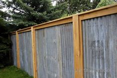 a long wooden fence next to a grassy field