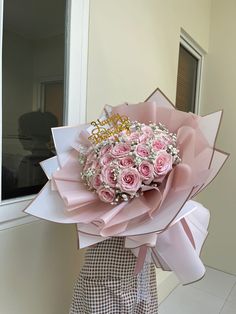 a woman holding a bouquet of pink roses