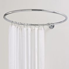 a white shower curtain hanging on a metal rod with two rings attached to the side