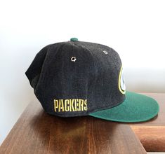 New Era Fifty Nine Fifty Green Bay Packers Snapback Hat. This is a great hat with solid quality and a unique design not only on the hat but the bill as well. Awesome look, perfect for the season to start. Retro Snapback Hat With Flat Brim For Fan Gear, Retro Flat Brim Snapback Hat For Fan Gear, Retro Fitted Hat With Flat Bill For Fans, Sports Event Fitted Hat With Flat Brim, Vintage Snapback Fitted Hat For Outdoor, Retro Fitted Hat With Flat Brim For Sports Events, Vintage Adjustable Baseball Cap For Fans, Vintage Adjustable Baseball Cap For Fan Gear, Adjustable Vintage Baseball Cap For Fans