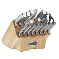 a set of knives sitting on top of a wooden block in front of a white background