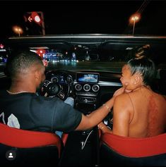 a man and woman sitting in the back of a car at night with their backs to each other