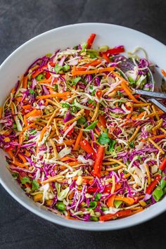 a white bowl filled with coleslaw and carrots on top of a table