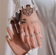 a woman's hand with tattoos on it and a tiger drawn on the wrist