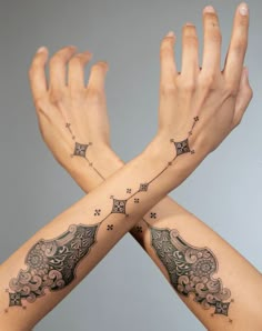 two hands with tattoos on their arms