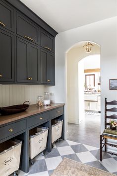 a large kitchen with black cabinets and white checkered flooring on the tile floors