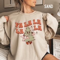 Christmas Sweatshirt for Women, Fa La La Sweatshirt, Retro Christmas Sweater, Trendy Christmas Tree Crewneck, Holiday Sweatshirt SIZE UP for an OVERSIZED look (see size chart in listing photos) Looking for more Christmas themed apparel? Check these out: https://www.etsy.com/shop/TheGraphicPeach?ref=seller-platform-mcnav§ion_id=30496778 Our shop uses direct-to-garment printing to make our products. The design ink is sprayed on, then allowed to soak into the fibers of the garment. This process yie Holiday Sweatshirts, Crop Top Suit, Coffee Sweatshirt, Sweater Crop, Party Dress Long Sleeve, Christmas Party Dress, Vintage Party, Sweatshirt Christmas, Christmas Hoodies