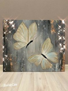 two white butterflies on a black and silver background with sparkles in the light behind them