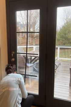 a woman sitting in front of a sliding glass door