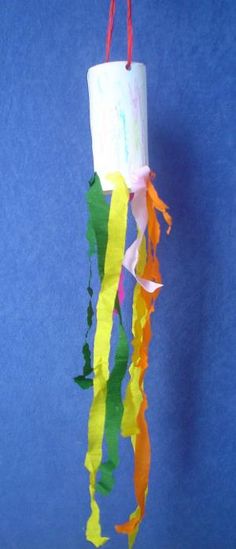 a paper roll hanging from a string on a blue wall