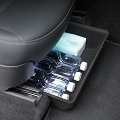 the interior of a car with two cups and napkins in it's compartment