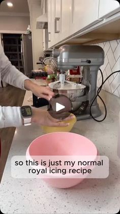 a woman is mixing food in a bowl on the kitchen counter with an appliance behind her