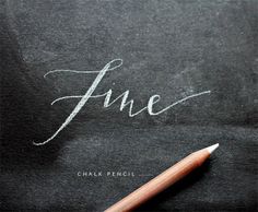 a pencil sitting on top of a blackboard with the word fine written in chalk