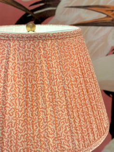 an orange and white lamp shade sitting on top of a table