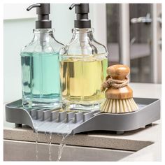 two soap dispensers sitting on top of a counter