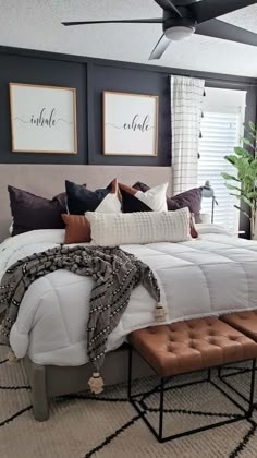 a bedroom with black walls, white bedding and brown accents on the headboard