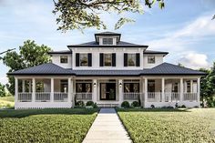 a white two story house with black shutters on the front and side porches