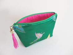 Handmade clutch bag made out of a green satin butterfly fabric, with a contrasting bright pink cotton lining. The bag has a green zipper closure with a pink tassel clipped on the zipper pull. Approximate size: 6.5in x 9.5in (16.5cm x 24cm). Materials: Satin fabric, cotton fabric, padding, zipper and tassel. This is a perfect size for phone, keys and purse, or as a cosmetic bag. I like to use it as a travel bag. By keeping all the essentials in one place, nothing gets forgotten. Please see the th Elegant Green Bag With Zipper Pouch, Green Clutch Pouch For Gifts, Handmade Clutch, Green Handbag, Pink Tassel, Green Satin, Pink Cotton, Emerald Green, Bright Pink