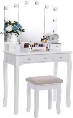 a white vanity table with a stool and mirror on it's sides, next to a vase with flowers