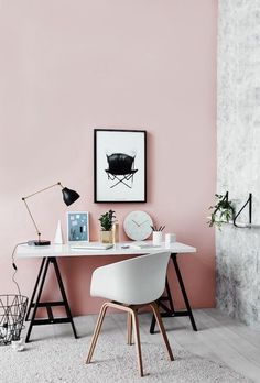 an image of a room with pink walls and white furniture in the corner, including a desk