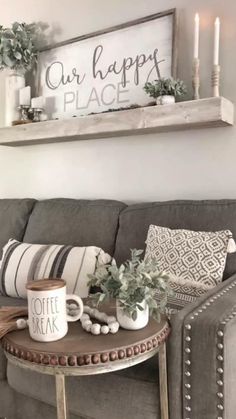 a living room with a gray couch and coffee table in front of a window that says our happy place