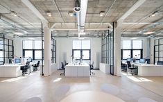 an empty office with lots of desks and chairs in the middle of the room