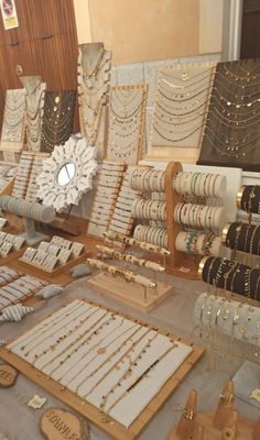 a table filled with lots of different types of bracelets and necklaces on display