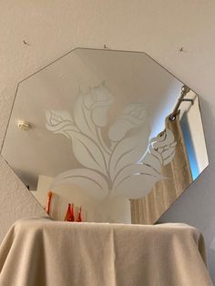 a mirror that is on the wall above a table with a cloth draped over it