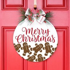 a red door with a merry christmas ornament hanging on it