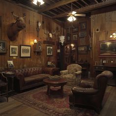 a living room filled with furniture and deer heads on the wall