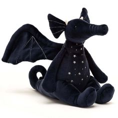 a black dragon stuffed animal sitting on the ground