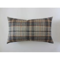 a plaid pillow sitting on top of a white wall