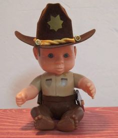 a toy cowboy sitting on top of a wooden table