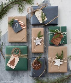 many wrapped presents are sitting on the table with twine and ribbons tied around them