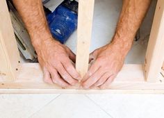 a man is working on some wood with his hands in the hole between two pieces of plywood