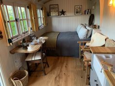 a bedroom with a bed, desk and chair in the corner next to a window