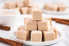 a white plate topped with pieces of cake next to cinnamon sticks