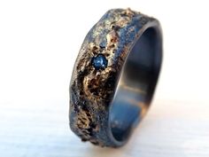 a ring that has been made to look like it is covered in dirt and blue stones