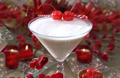 a martini with cherries on the rim and garnished with candy canes