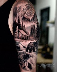 a man's arm with a bear and cabin in the woods tattoo on it