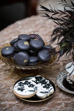 two plates with cookies on them sitting on a table next to a vase filled with flowers