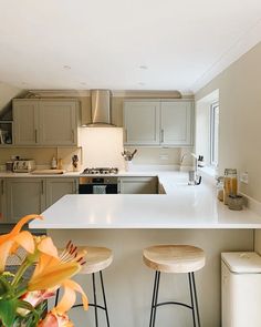 a kitchen with two stools next to a counter top and an island in the middle