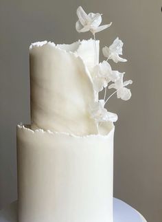 there is a white cake with flowers on the top and bottom layer, which has been frosted in icing