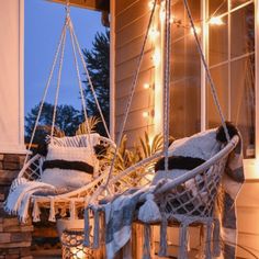 two white chairs sitting on top of a porch covered in snow